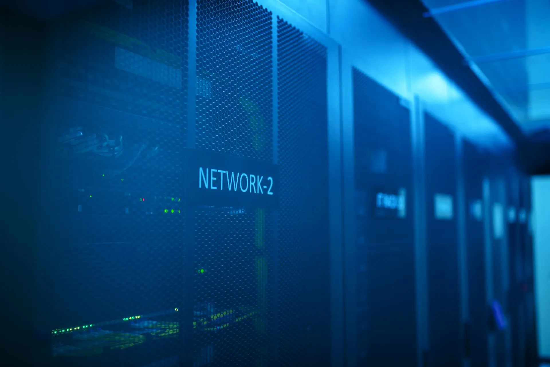Corredor de data center com racks de servidores e iluminação técnica